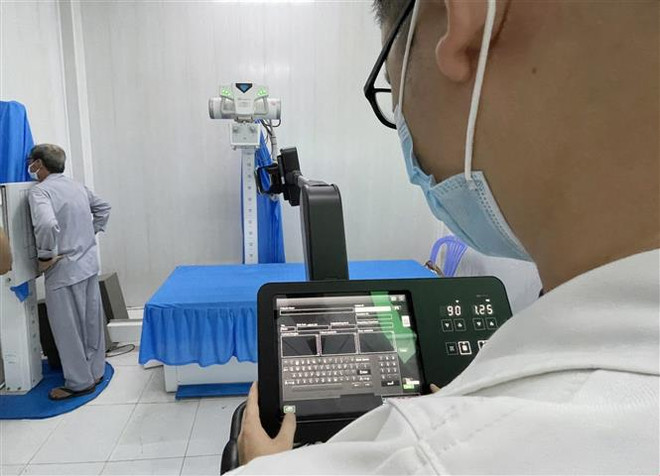 Người dân xã đảo Thạnh An, huyện Cần Giờ, Thành phố Hồ Chí Minh được chụp X-quang phổi bằng máy tích hợp trí tuệ nhân tạo. (Ảnh: TTXVN phát) Ngành y tế TP.HCM chuyển đổi số: Những bước "chuyển mình" đầu tiên ảnh 3