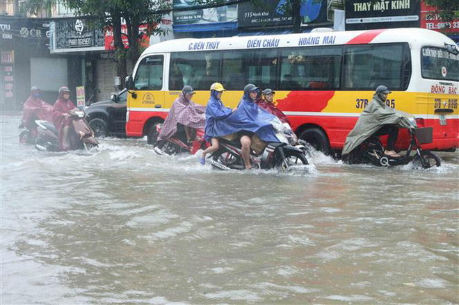 Các phương tiện di chuyển khó khăn tại thành phố Vinh, tỉnh Nghệ An. (Ảnh: Nguyễn Oanh/TTXVN) Kiểm tra công tác khắc phục ngập úng do mưa lớn tại thành phố Vinh ảnh 1