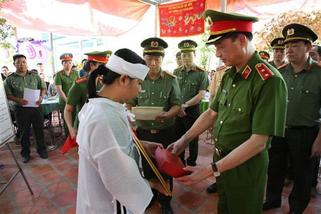 Trung tướng Nguyễn Duy Ngọc, Thứ trưởng Bộ Công an, trao quyết định của Bộ trưởng Bộ Công an về việc truy thăng cấp bậc hàm từ Thiếu tá lên Trung tá đối với chiến sỹ Nguyễn Xuân Hào. (Ảnh: TTXVN phát) Truy thăng cấp Trung tá cho chiến sỹ công an hy sinh khi làm nhiệm vụ ảnh 1