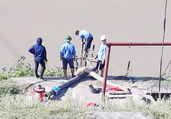 Lực lượng chức năng lắp đặt trạm bơm dã chiến để lấy nước sản xuất tại huyện Đô Lương. (Ảnh: TTXVN phát) Nghệ An: Chủ động phòng chống hạn hán sau sự cố vỡ đập Bara Đô Lương ảnh 1