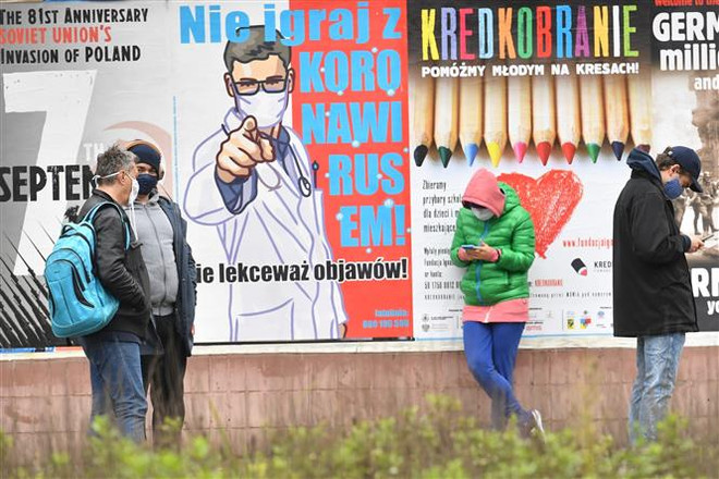 Người dân đeo khẩu trang phòng lây nhiễm COVID-19 tại Warsaw, Ba Lan. (Ảnh: PAP/TTXVN) Hàng triệu người dân châu Âu phải chịu cảnh phong tỏa do COVID-19 ảnh 2