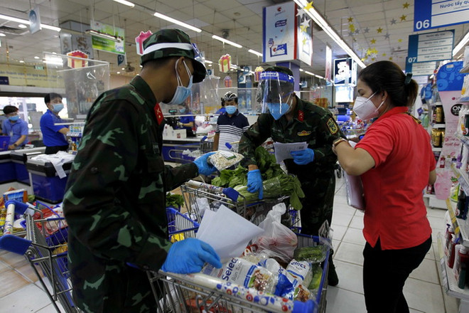 Nhiều chiến sỹ nhờ trợ giúp thông tin, hàng hóa từ các nhân viên siêu thị để "đi chợ giúp dân" đúng và đầy đủ theo nhu cầu." (Ảnh: Thanh Vũ/TTXVN) Quá trình TP.HCM thực hiện NQ86: Điều chỉnh, linh động các giải pháp ảnh 3