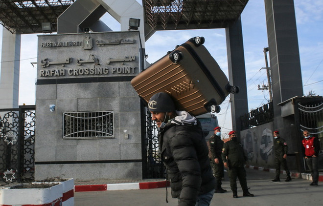 Người dân Palestine đi qua cửa khẩu Rafah ở khu vực biên giới phía Nam Dải Gaza, giáp Ai Cập. (Ảnh: AFP/TTXVN) Ai Cập mở lại cửa khẩu Rafah sớm hơn một ngày so với kế hoạch ảnh 1