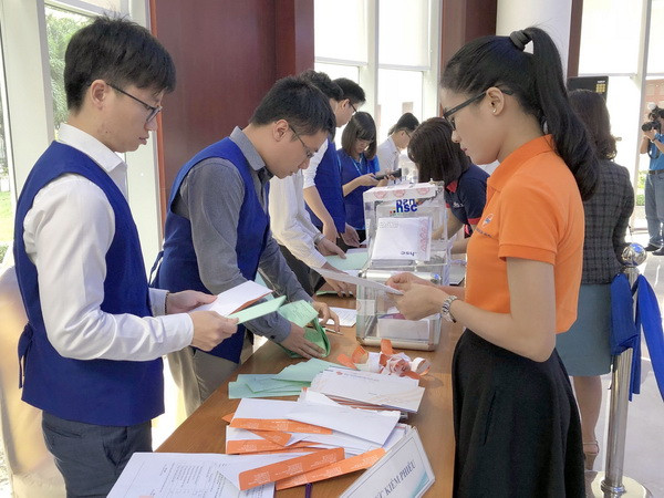Chuyên viên HOSE thực hiện quy trình kiểm tra phiếu tham gia Phiên đấu giá. (Ảnh: Mỹ Phương/TTXVN) Tập đoàn Công nghiệp Cao su chỉ bán được 1/4 khối lượng cổ phần IPO ảnh 2