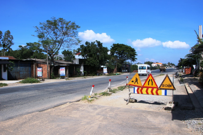 Khu vực thi công dở dang được đặt biển cảnh báo. (Ảnh: Đinh Hương/TTXVN) Tập trung giải quyết vướng mắc tại dự án nâng cấp, mở rộng Quốc lộ 1A ảnh 1