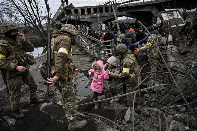 Người dân Ukraine sơ tán tránh chiến sự tại thành phố Irpin, phía Tây Bắc Kyiv, Ukraine. (Ảnh: AFP/TTXVN) Mỹ dỡ bỏ hạn chế chia sẻ thông tin tình báo với Ukraine ảnh 1