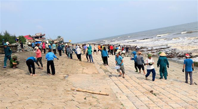 Hàng trăm người vận chuyển đá gia cố thân kè biển bị sạt lở. (Ảnh: Công Tường/TTXVN) Bão số 4-Noru: Hà Tĩnh khẩn trương củng cố tuyến kè biển xung yếu ảnh 2