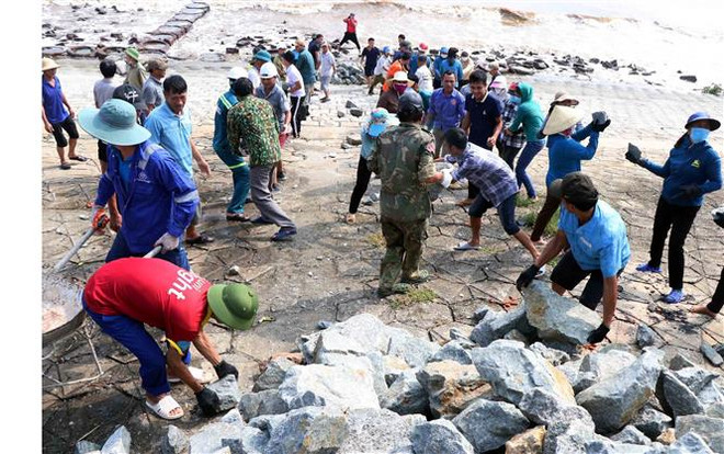 Người dân thôn Hải Nam, xã Cẩm Nhượng (Cẩm Xuyên, Hà Tĩnh) gia cố tuyến kè biển bị sạt lở. (Ảnh: Công Tường/TTXVN) Bão số 4-Noru: Hà Tĩnh khẩn trương củng cố tuyến kè biển xung yếu ảnh 1