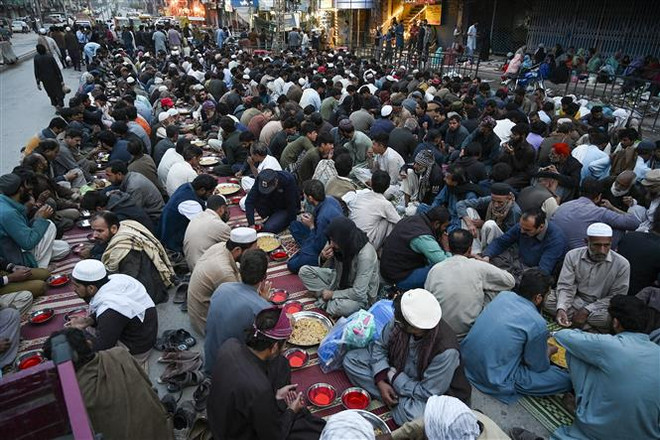 Các tín đồ Hồi giáo dùng bữa sáng trong ngày đầu tiên của tháng lễ Ramadan ở Rawalpindi, Pakistan, ngày 23/3. (Ảnh: AFP/TTXVN) Pakistan: Giẫm đạp lúc nhận đồ miễn phí, ít nhất 9 người thiệt mạng ảnh 1