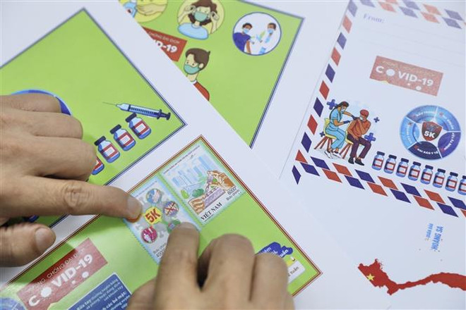 Người sưu tập tem đến mua, sử dụng bộ tem mới được phát hành. (Ảnh: Minh Quyết/TTXVN) Phát hành bộ tem Chung sống an toàn với đại dịch COVID-19 ảnh 2
