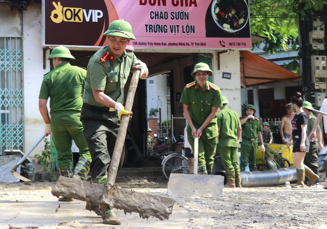 Lực lượng Công an được huy động hỗ trợ dọn bùn, giúp người dân thành phố Yên Bái sớm ổn định cuộc sống sau đợt lũ. (Ảnh: Tuấn Anh/TTXVN) ttxvn_yen bai don ve sinh sau bao2.jpg