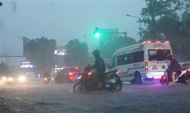 Các phương tiện tham gia giao thông gặp khó khăn do mưa lớn. (Ảnh: Nguyễn Oanh/TTXVN) Bắc Bộ và Trung Bộ giảm mưa, Nam Bộ mưa dông, đề phòng ngập úng ảnh 1