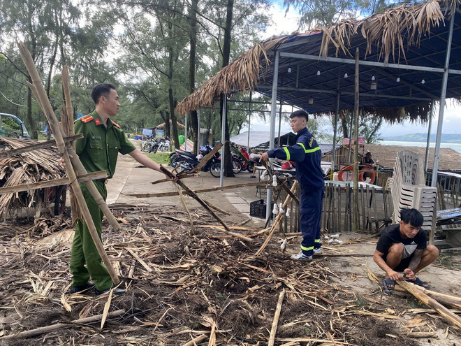 Lực lượng Công an, Cảnh sát huyện Cô Tô giúp người dân thu dọn sau cơn bão số 2. (Ảnh: Thu Báu/TTXVN phát) ttxvn_2507_quang ninh.jpg