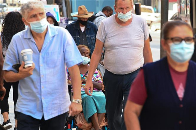 Người dân đeo khẩu trang phòng lây nhiễm COVID-19 tại Los Angeles, California, Mỹ. (Ảnh: AFP/TTXVN) Dịch COVID-19: Mỹ chưa thể trở lại bình thường trước cuối năm 2021 ảnh 1