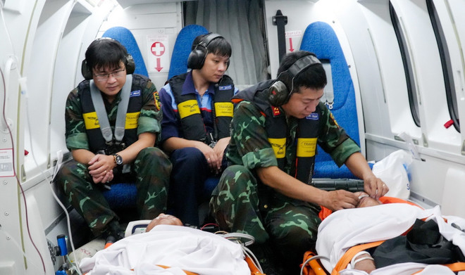 Các bác sỹ theo dõi người bệnh trong suốt quá trình vận chuyển từ Trường Sa về đất liền. (Ảnh: TTXVN phát) ttxvn_1106_cap cuu (2).jpg
