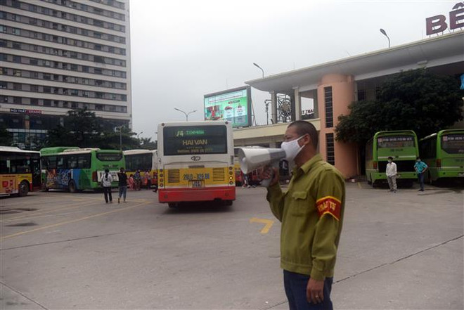 Các bến xe cử người nhắc người dân đeo khẩu trang khi vào bến. (Ảnh: Nguyễn Văn Cảnh/TTXVN) Dịch COVID-19: Ngăn chặn nguồn lây bệnh từ dịch vụ vận tải ảnh 1