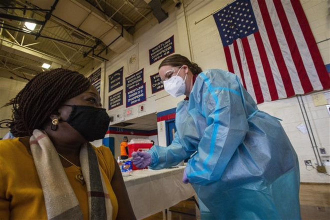 Nhân viên y tế tiêm vaccine phòng COVID-19 của Moderna cho người dân tại Central Falls, Rhode Island, Mỹ. (Ảnh: AFP/TTXVN) Dịch COVID-19: Mỹ nới lỏng hạn chế đối với người đã tiêm phòng ảnh 1