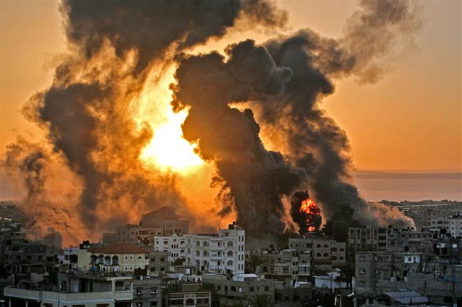Khói lửa bốc lên sau loạt không kích của Israel xuống thị trấn Khan Yunis ở Dải Gaza ngày 12/5. (Ảnh: AFP/TTXVN) Israel bắt đầu triển khai lục quân và không quân tấn công Gaza ảnh 1