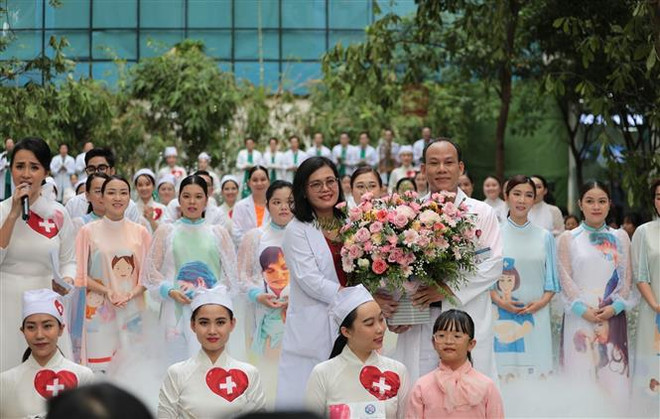 Phó Giáo sư, Tiến sỹ, Bác sỹ Hoàng Thị Diễm Tuyết, Giám đốc Bệnh viện Hùng Vương nhận hoa cảm ơn từ Ban tổ chức Chương trình "Mầm sống." (Ảnh: Đinh Hằng/TTXVN) Hơn 100 y, bác sỹ vào vai ca sỹ, người mẫu trong ''Mầm sống'' ảnh 2