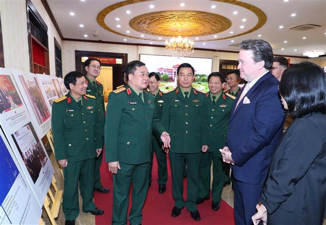 Thượng tướng Hoàng Xuân Chiến, Thứ trưởng Bộ Quốc phòng và Đại sứ Hoa Kỳ tại Việt Nam Marc E. Knapper tham quan Trưng bày ảnh về công tác khắc phục hậu quả bom, mìn sau chiến tranh ở Việt Nam. (Ảnh: Trọng Đức/TTXVN) Việt Nam-Hoa Kỳ thúc đẩy hợp tác khắc phục hậu quả bom mìn ảnh 3