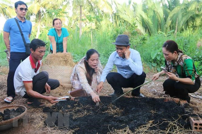 Du khách tự tay nướng trứng gà bọc đất sét tại Cồn Hô. (Ảnh: Thanh Hòa/TTXVN) Khai thác tiềm năng và thế mạnh để phát triển du lịch biển Trà Vinh ảnh 3