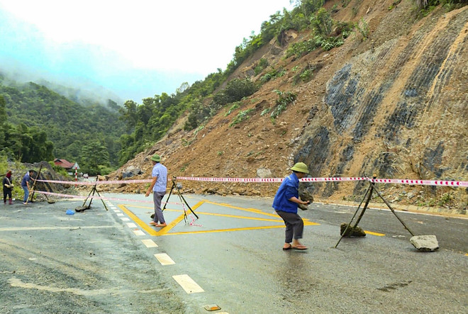 Lực lượng chức năng đặt biển cảnh báo, phân luồng giao thông tại điểm sạt lở. (Ảnh: TTXVN phát) ttxvn_2108_sat lo quoc lo 12 (2).jpg