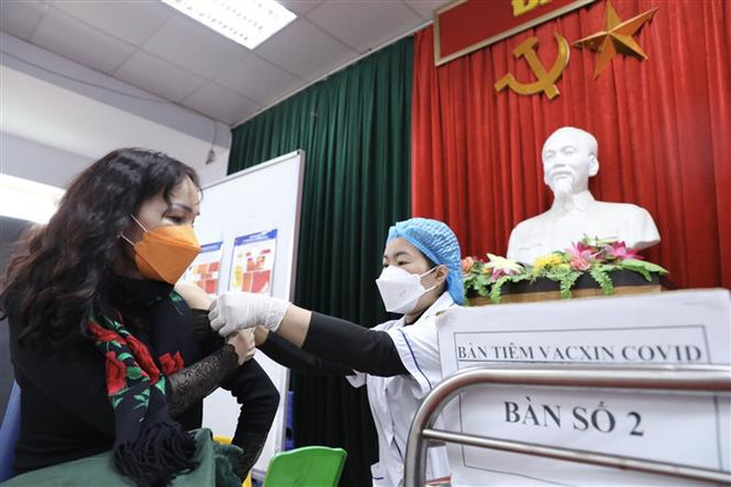 Nhân viên y tế quận Hai Bà Trưng, Hà Nội, tiêm vaccine phòng COVID-19 cho người dân. (Ảnh: Minh Quyết/TTXVN) Số ca mắc mới COVID-19 lại gia tăng trong những ngày giáp Tết ảnh 1