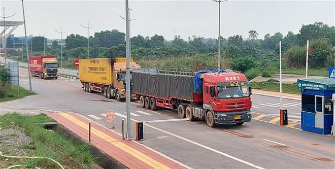 Xe vận chuyển hàng hóa qua Cửa khẩu quốc tế Móng Cái. (Ảnh: Văn Đức/TTXVN) Đưa Móng Cái trở thành cửa ngõ xuất nhập khẩu hàng nông, thủy sản ảnh 1