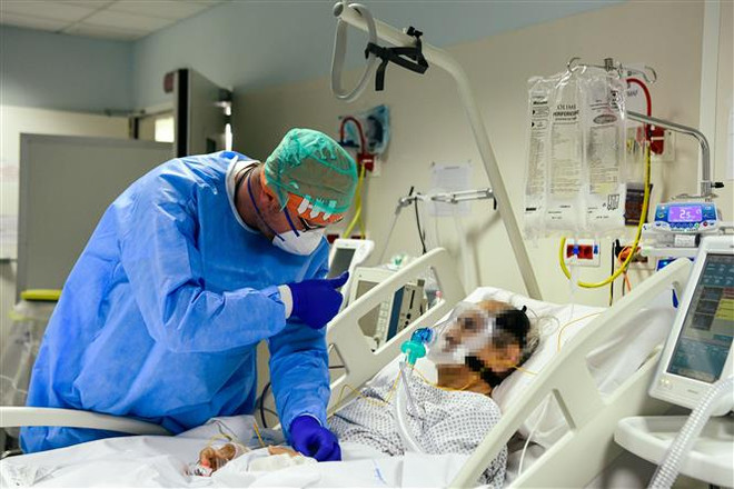 Nhân viên y tế chăm sóc bệnh nhân COVID-19 tại bệnh viện ASST Papa Giovanni XXIII ở Bergamo, Italy. (Ảnh: AFP/TTXVN) WHO: Chưa thể xác minh nguồn gốc của virus SARS-CoV-2 ảnh 1
