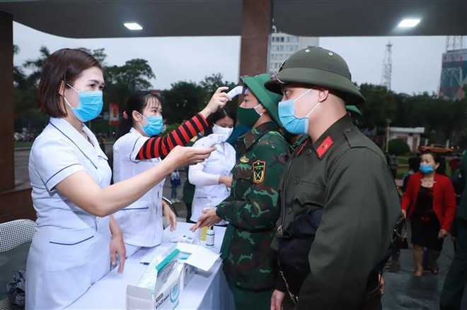Các tân binh được đo thân nhiệt, đeo khẩu trang vải, sát khuẩn, giữ khoảng cách đảm bảo an toàn phòng chống dịch. (Ảnh: Bích Huệ/TTXVN) Quân khu 4 tổ chức giao nhận quân nhanh gọn, an toàn, tiết kiệm ảnh 2