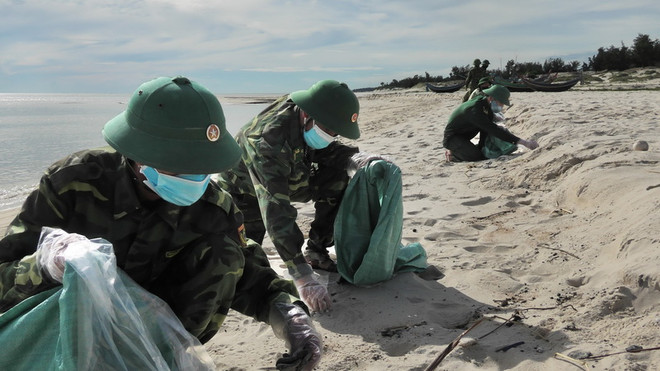 Tỉnh Quảng Bình thu gom khoảng 750kg dầu dạt vào bờ biển ảnh 1