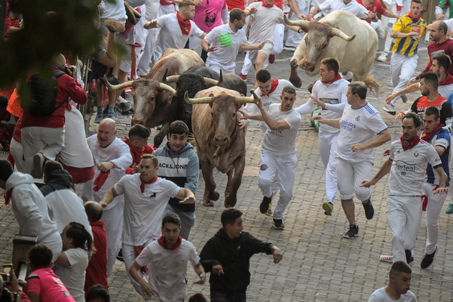 Những con bò tót chạy đua cùng dòng người tham gia lễ hội nổi tiếng San Fermín trên quãng đường tới trường đấu bò ở thành phố Pamplona, Tây Ban Nha ngày 6/7. (Ảnh: AFP/TTXVN) Tây Ban Nha: Ba người thiệt mạng trong các lễ hội chạy đua với bò tót ảnh 1