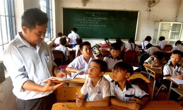 Các học sinh đến lớp ở điểm trường lẻ phải học ghép lớp trong một phòng học ở ấp 7, xã Tân Lập, huyện Đồng Phú, tỉnh Bình Phước. (Ảnh: Dương Chí Tưởng/TTXVN) Giải trình về tuyển dụng giáo viên và tổ chức Kỳ thi THPT quốc gia ảnh 2