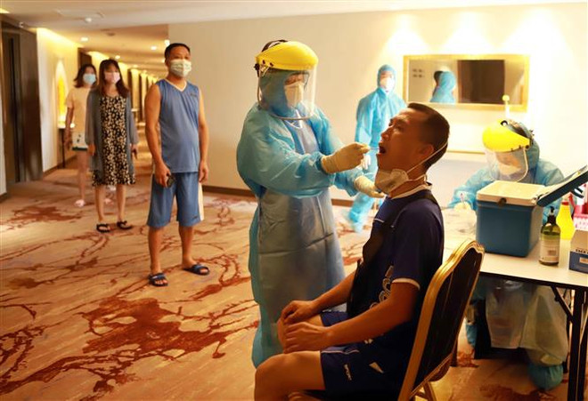 Lấy dịch xét nghiệm tìm virus SARS-CoV-2 ở tại Khách sạn DIC STAR thành phố Vĩnh Yên, Vĩnh Phúc. (Ảnh: Hoàng Hùng/TTXVN) Tăng cường kiểm soát nhập cảnh, quản lý người nước ngoài nhập cảnh ảnh 1