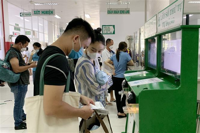 Bệnh nhi đến khám bệnh tại Bệnh viện Nhi đồng 2, Thành phố Hồ Chí Minh. (Ảnh: Đinh Hằng/TTXVN) Nắng nóng kéo dài, bệnh nhi và người già nhập viện tăng cao ảnh 2