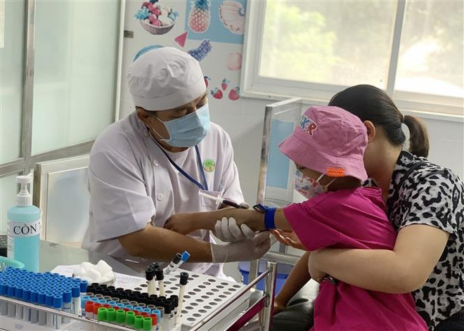 Bệnh nhi đến khám bệnh tại Bệnh viện Nhi đồng 2, Thành phố Hồ Chí Minh. (Ảnh: Đinh Hằng/TTXVN) Nắng nóng kéo dài, bệnh nhi và người già nhập viện tăng cao ảnh 1