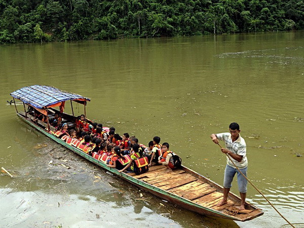 Các thầy Trường Phổ thông dân tộc bán trú Tiểu học số 1 xã Ta Gia đưa học sinh vượt sông Nậm Mu về trường. (Ảnh: Việt Hoàng/TTXVN) Lai Châu nỗ lực đưa học sinh dân tộc thiểu số đến trường ảnh 1