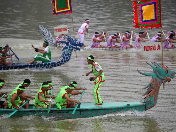 Các đội chải quyết liệt trên đường đua. (Ảnh: Thanh Tùng/TTXVN) Hàng nghìn người đến cổ vũ hội thi bơi chải Bạch Hạc trên sông Lô ảnh 1