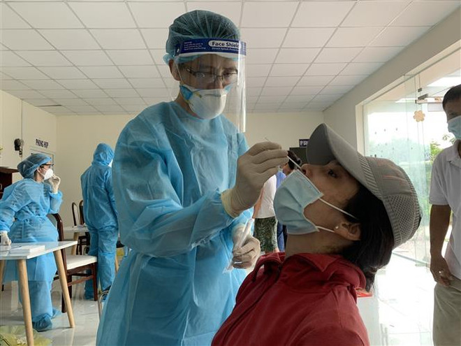 Nhân viên y tế lấy mẫu xét nghiệm COVID-19 cho người dân tại khu phố 1, phường 15, quận Gò Vấp. (Ảnh: TTXVN phát) TP Hồ Chí Minh tiếp tục là điểm nóng với 60 ca mắc COVID-19 sáng 18/6 ảnh 1