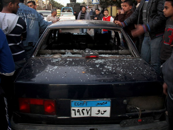 Xe ôtô bị phá hủy trong vụ đánh bom thứ 4 gần Kim tự tháp Giza ở Cairo ngày 24/1. (Nguồn: AFP/TTXVN) Người Ai Cập quyết thực hiện mục tiêu của ngày 25/1 ảnh 1