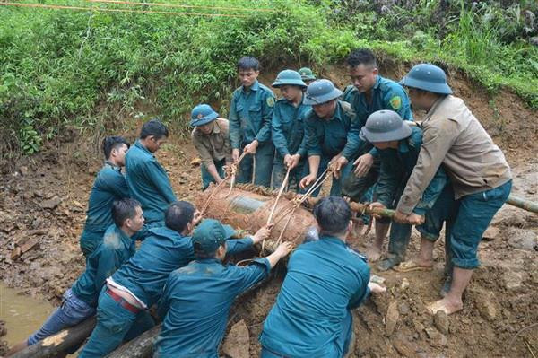 Chiến sỹ lực lượng vũ trang đưa bom xuống hố để hủy nổ. Ảnh minh họa. (Ảnh: TTXVN phát) Quảng Bình: Phát hiện quả bom nặng 350kg dưới móng nhà dân ảnh 1