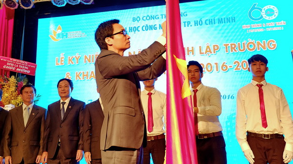 Phó Thủ tướng Vũ Đức Đam gắn Huân chương Độc lập Hạng Ba lên cờ truyền thống của Trường Đại học Công nghiệp Thành phố Hồ Chí Minh. (Ảnh: Thế Anh/TTXVN) Đại học Công nghiệp TP.HCM nhận Huân chương Độc lập hạng Ba ảnh 1