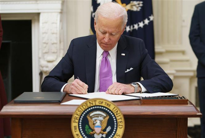 Tổng thống Mỹ Joe Biden ký một sắc lệnh hành pháp tại Nhà Trắng ở Washington, DC. (Ảnh: AFP/TTXVN) Tân Tổng thống Mỹ Joe Biden công bố một loạt chính sách mới ảnh 1