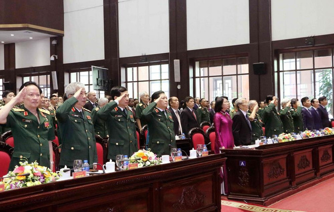 Các đại biểu thực hiện nghi thức chào cờ. (Ảnh: Văn Điệp/TTXVN) Cục Đối ngoại Bộ Quốc phòng nhận danh hiệu Anh hùng Lực lượng vũ trang ảnh 1