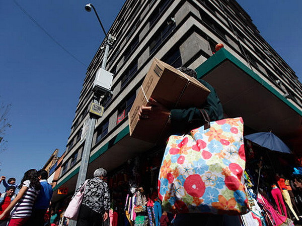 Một người đàn ông mang kiện hàng mới mua tại trung tâm thành phố Mexico City. (Nguồn: Reuters) GDP của Mexico tăng trưởng khoảng 3,4% năm nay ảnh 1