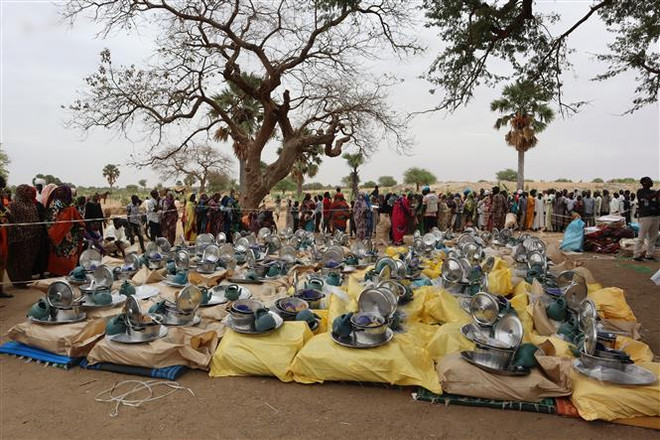 Phân phát hàng viện trợ cho người tị nạn Sudan tại Koufroun, Cộng hòa Chad. (Ảnh: AFP/TTXVN) Giao tranh tại Sudan: Hơn 250.000 người dân đã phải đi sơ tán ảnh 1
