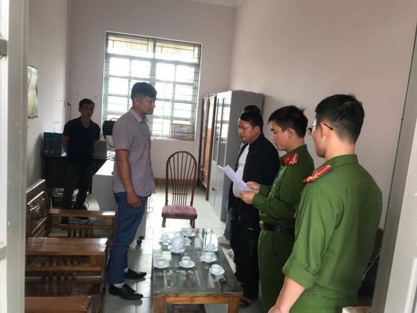 Ông Nông Văn Hoành (bìa trái) nghe đọc quyết định tạm giữ hình sự, điều tra về hành vi Lạm dụng chức vụ quyền hạn chiếm đoạt tài sản. (Ảnh: TTXVN phát) Cao Bằng: Bắt nguyên Phó Giám đốc Văn phòng đăng ký đất đai ảnh 1