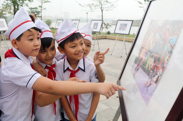 Các em học sinh xem Triển lãm ảnh. (Ảnh: Trung Kiên/TTXVN) Hội sách Đất Tổ và Triển lãm ảnh nghệ thuật về quê hương Phú Thọ ảnh 2