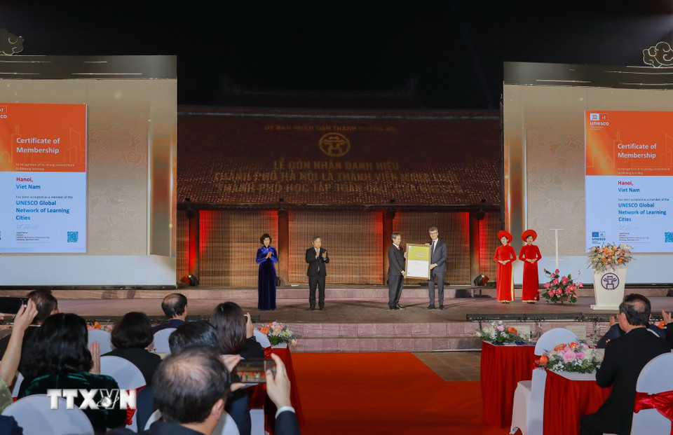 Ông Jonathan W. Baker, Trưởng đại diện UNESCO tại Việt Nam trao danh hiệu cho Phó Giáo sư, Tiến sỹ Nguyễn Kim Sơn Ủy viên Trung ương Đảng, Bộ trưởng Bộ Giáo dục và Đào tạo. (Ảnh: Phan Phương/TTXVN)