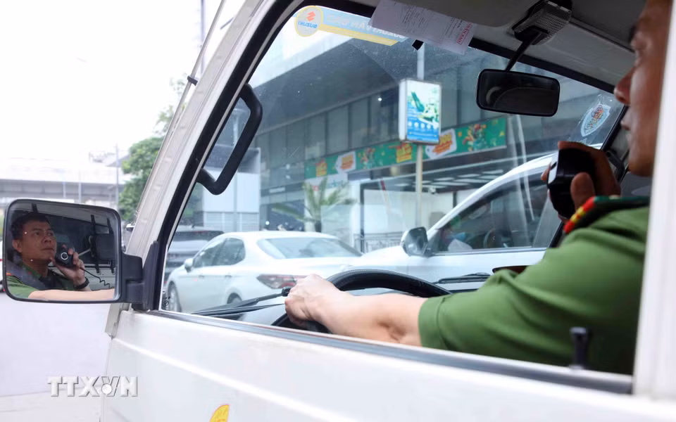 Công an phường Phương Liệt phát loa nhắc nhở các phương tiện giao thông dừng, đỗ sai quy định trên phố Lê Trọng Tấn. (Ảnh: Phạm Kiên/TTXVN)